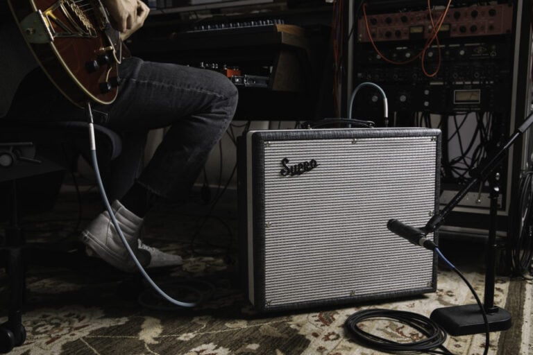 a person playing guitar next to a speaker