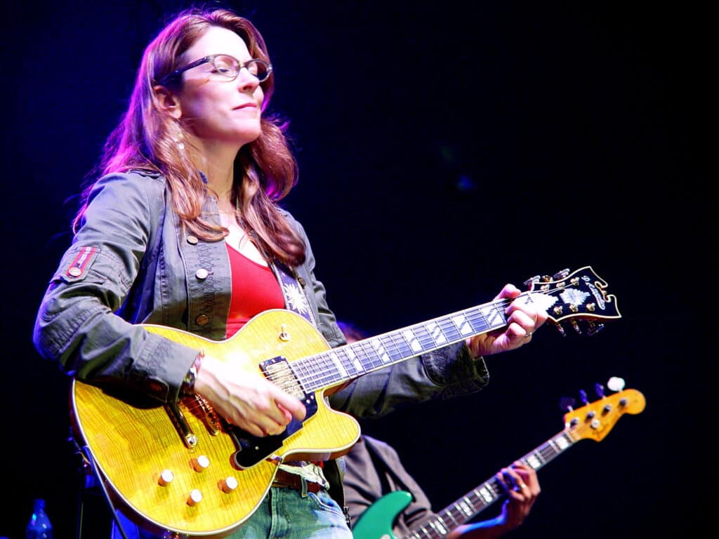 a woman playing d'angelico guitar