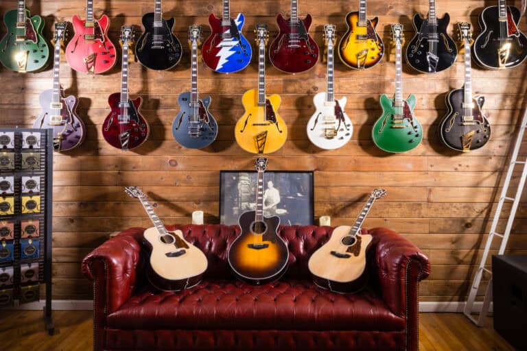a group of guitars on a couch in d'angelico guitars showroom