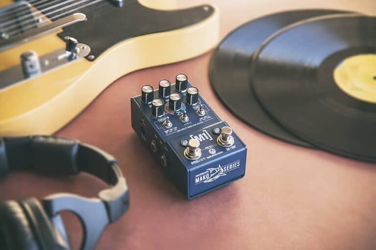 Walrus Audio MAKO Series M1 High-Fidelity Modulation Machine guitar pedal on table next to records, headphones, and a fender telecaster