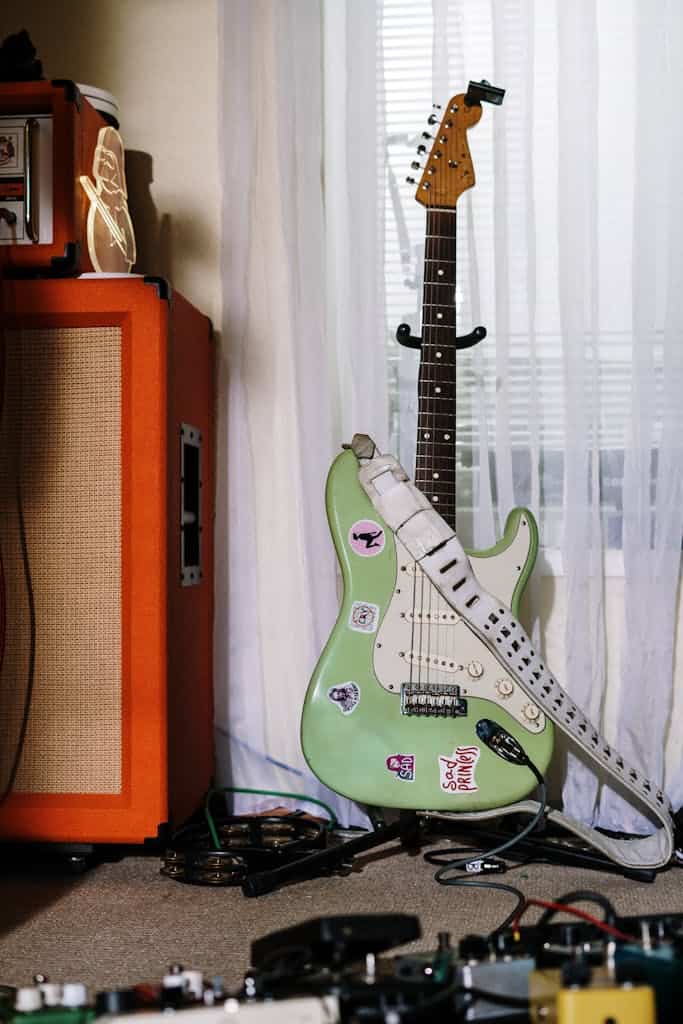 a guitar leaning against an orange speaker